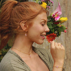 Detail van lichtroze rozenkwarts hanger aan goudkleurige ketting