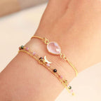 Detail van facetgeslepen rozenkwarts aan goudkleurige armband